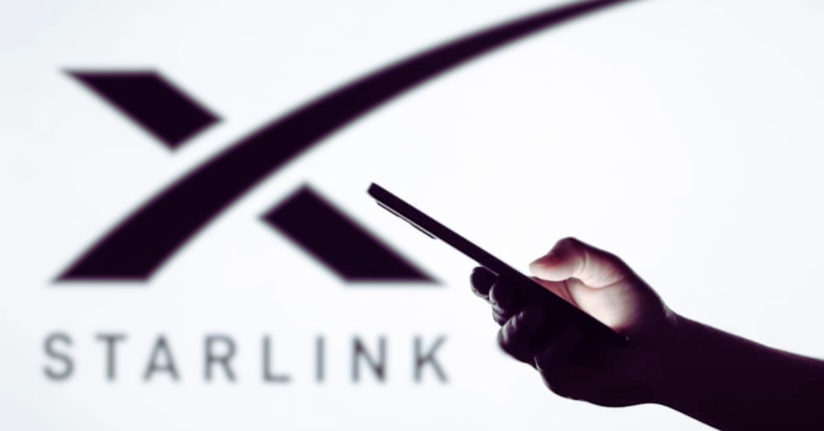 Hand holding smartphone in front of Starlink logo, representing satellite internet launch in Pakistan.